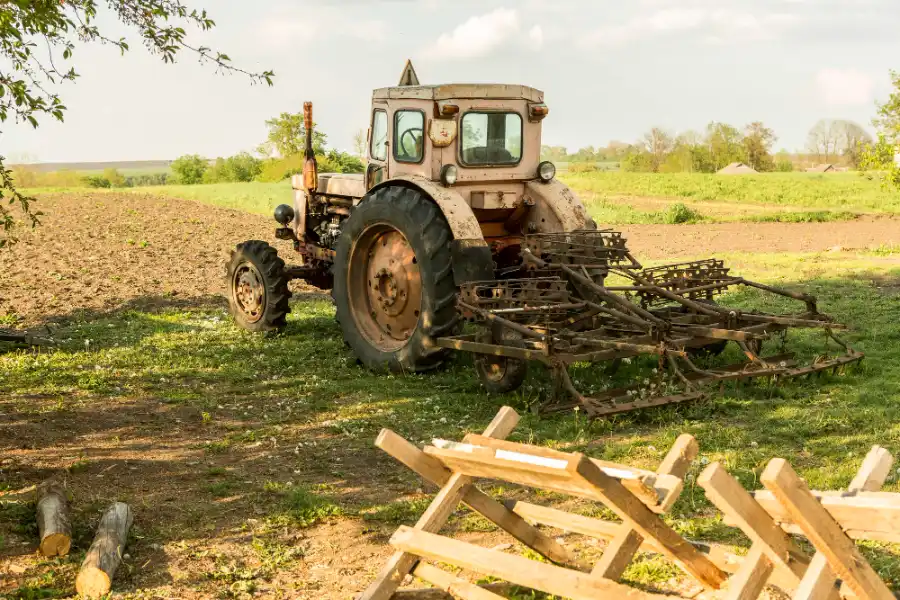Old farm tractor and cultivation equipment awaiting scrap metal recycling on a rural property in South Australia.