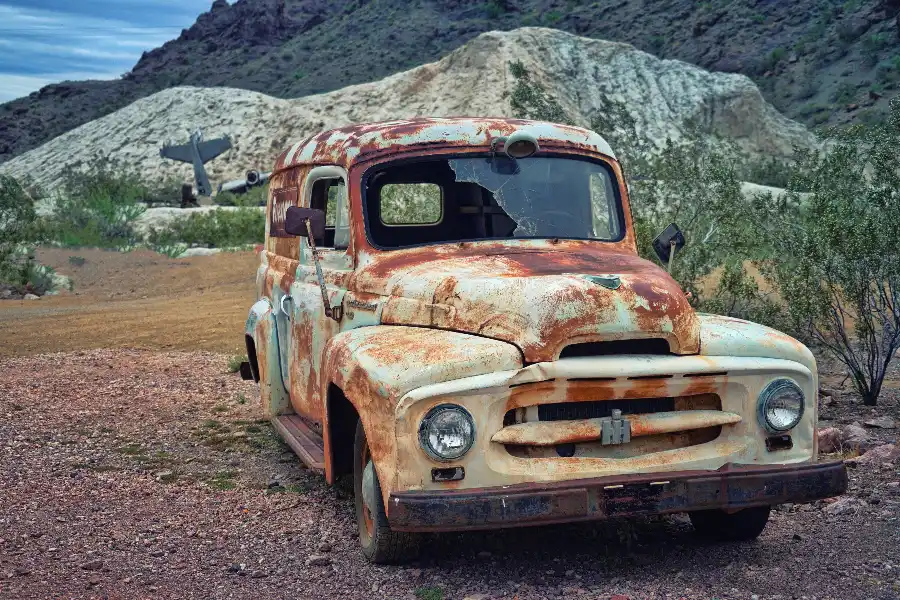 Old rusted vehicle suited to scrap car removal Old rusted vintage van with a cracked windscreen and peeling paint parked on gravel, an example of a scrap car